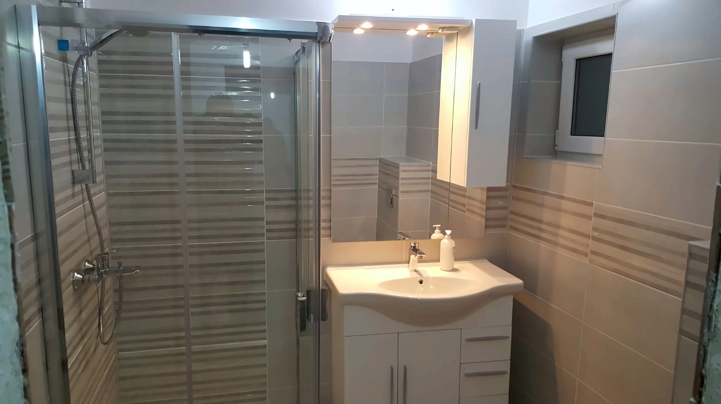 Baie renovată cu cabină de duș și mobilier alb, apartament din Sectorul 6, zona Politehnica