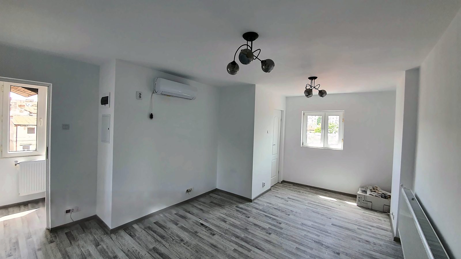 Cameră renovată cu pereți albi, parchet laminat și calorifere noi, apartament de 2 camere la Piața Unirii